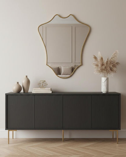 Shield-shaped brass wall mirror in modern interior