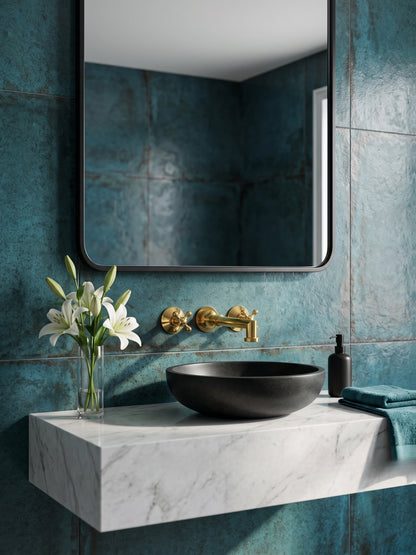 Luxury solid brass bathroom faucet with cross handles paired with a black stone vessel sink and blue tile wall.