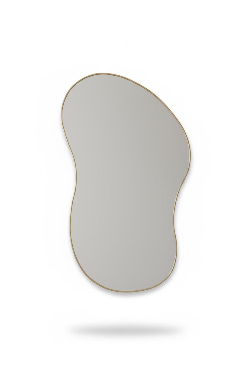 Asymmetrical curved brass mirror in a white background
