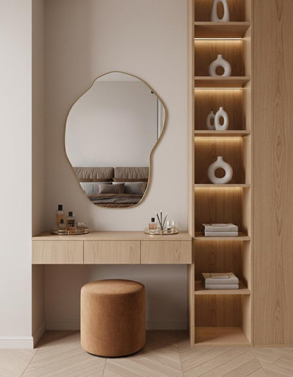 Organic shaped brass mirror in minimalist dressing area with wood shelves