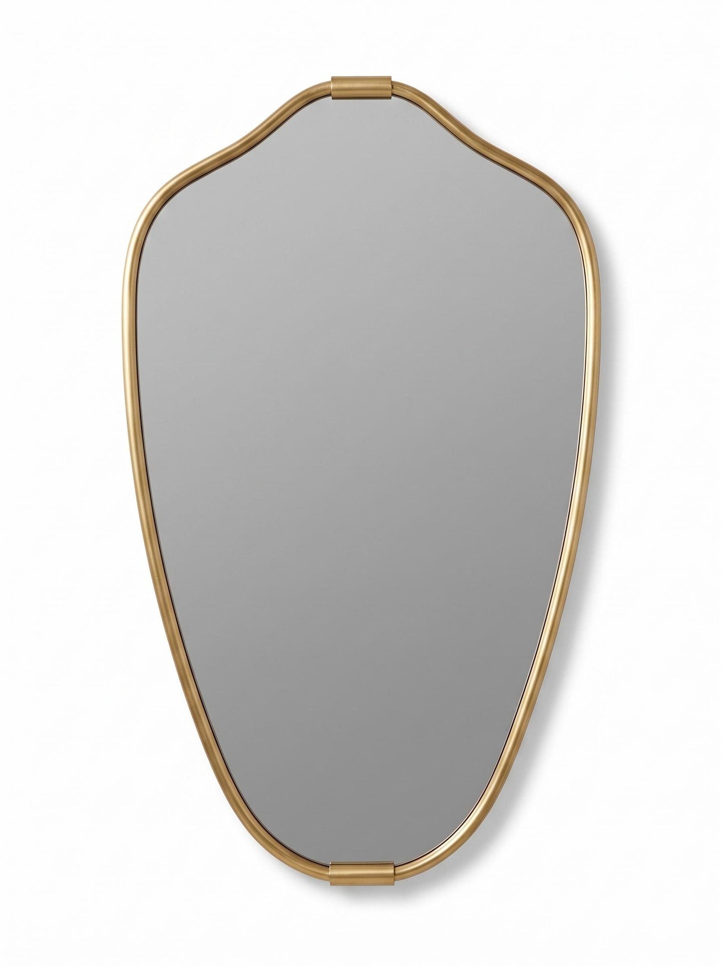 Curved brass vanity mirror with artistic gold frame on neutral background