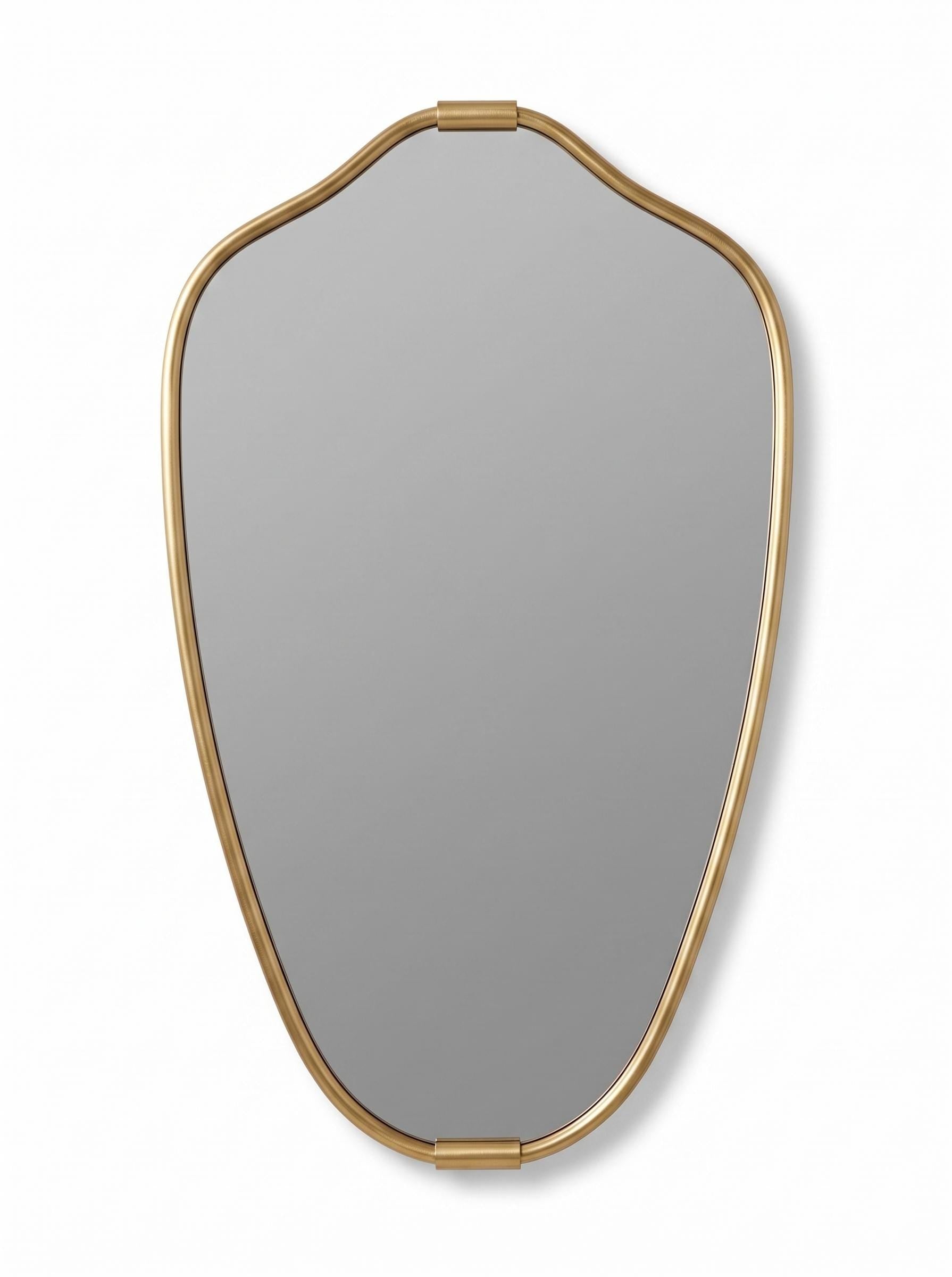 Curved brass vanity mirror with artistic gold frame on neutral background