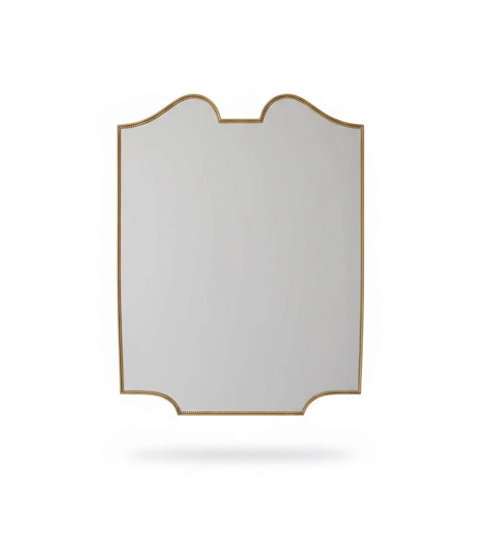 Scalloped brass mirror with curved frame in a white background.