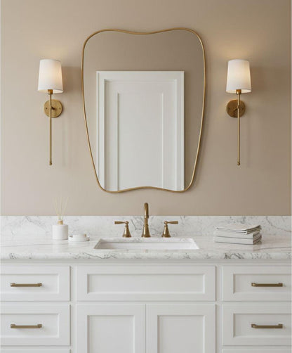 Soft curve brass wall mirror above bathroom vanity