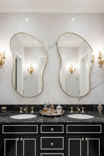 Curved asymmetrical brass bathroom mirrors above double vanity