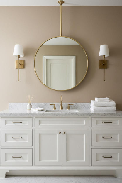 Round brass suspended bathroom mirror above white vanity