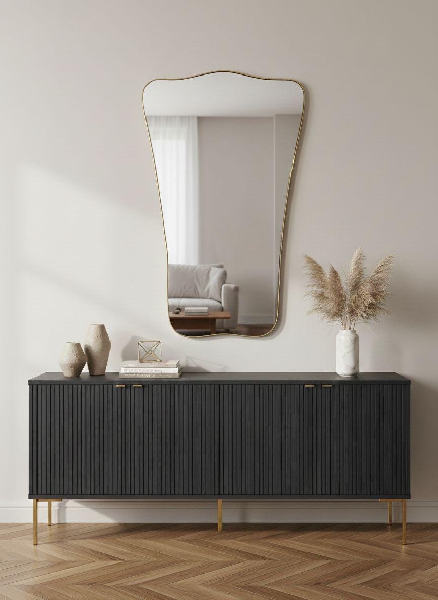 Sculptural brass wall mirror styled over modern black console