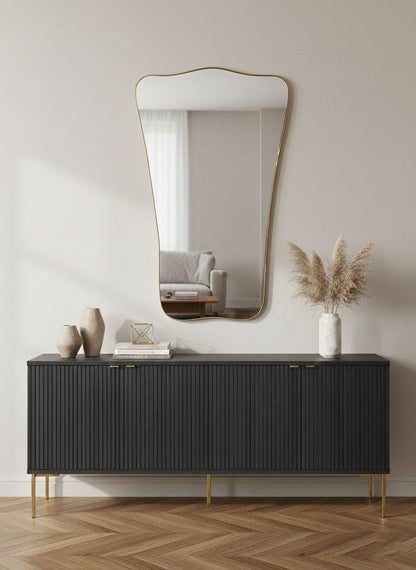 Sculptural brass wall mirror styled over modern black console