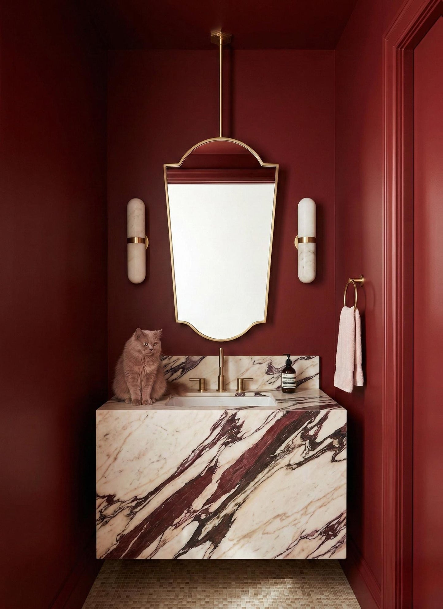 Suspended brass mirror in marble powder room