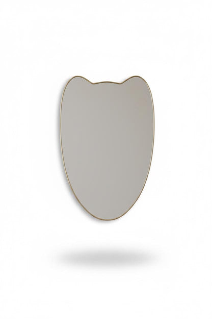 Curved crest brass mirror in a white background.