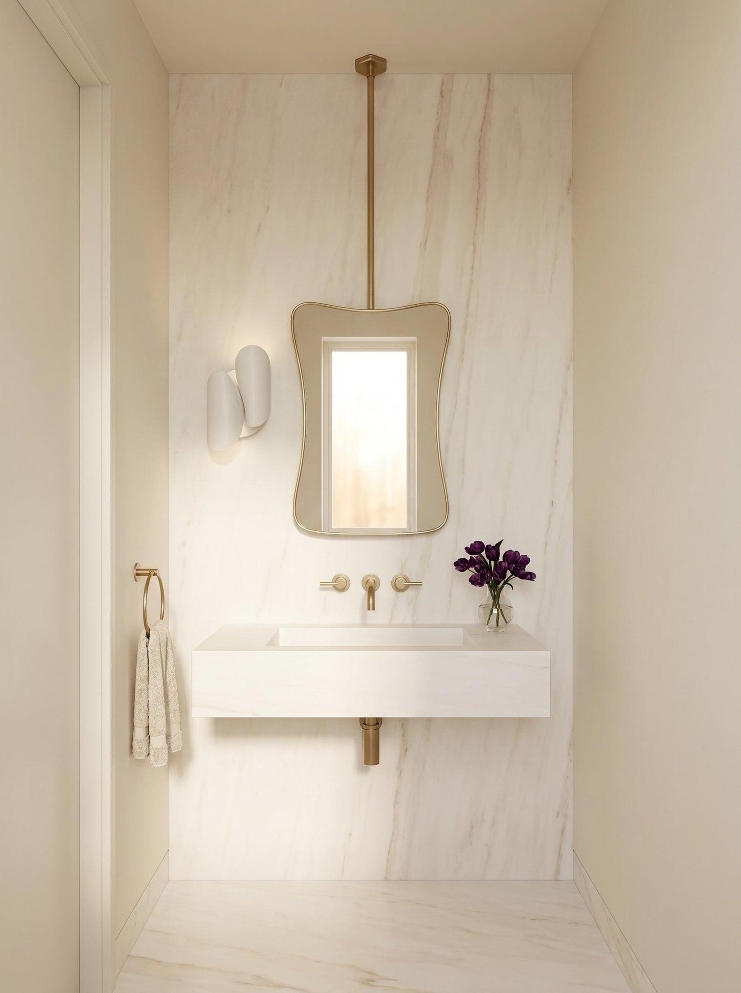 Sculptural brass hanging mirror above marble sink