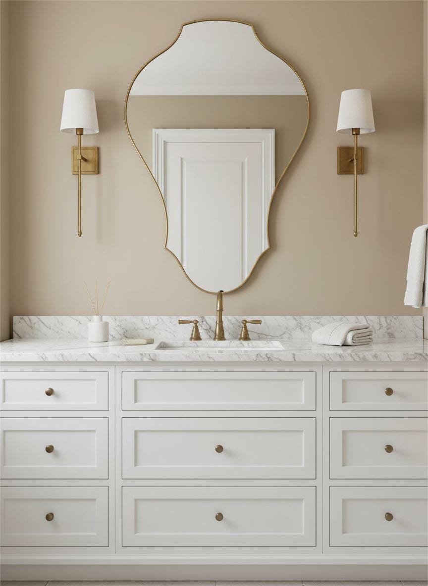 Asymmetrical unlacquered brass mirror over white bathroom vanity