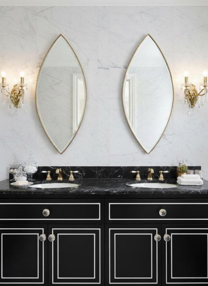 Pair of pointed oval brass mirrors over double vanity