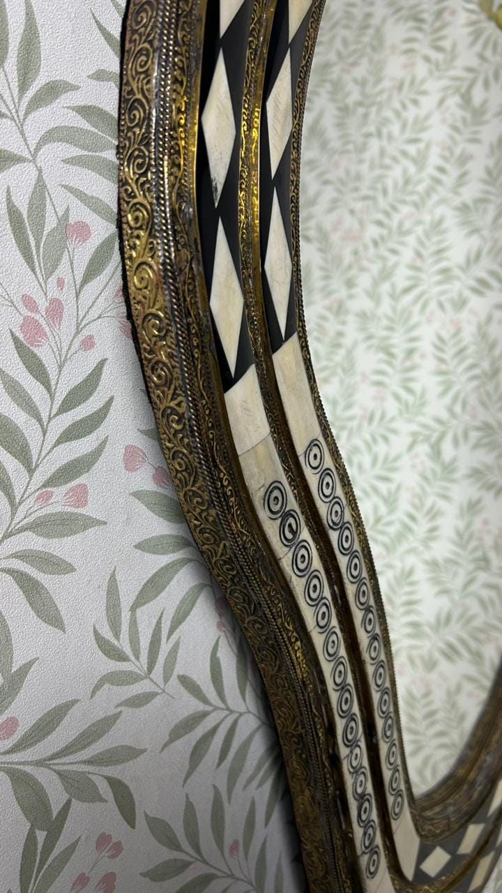 Close-up detail of bone inlay and engraved brass frame