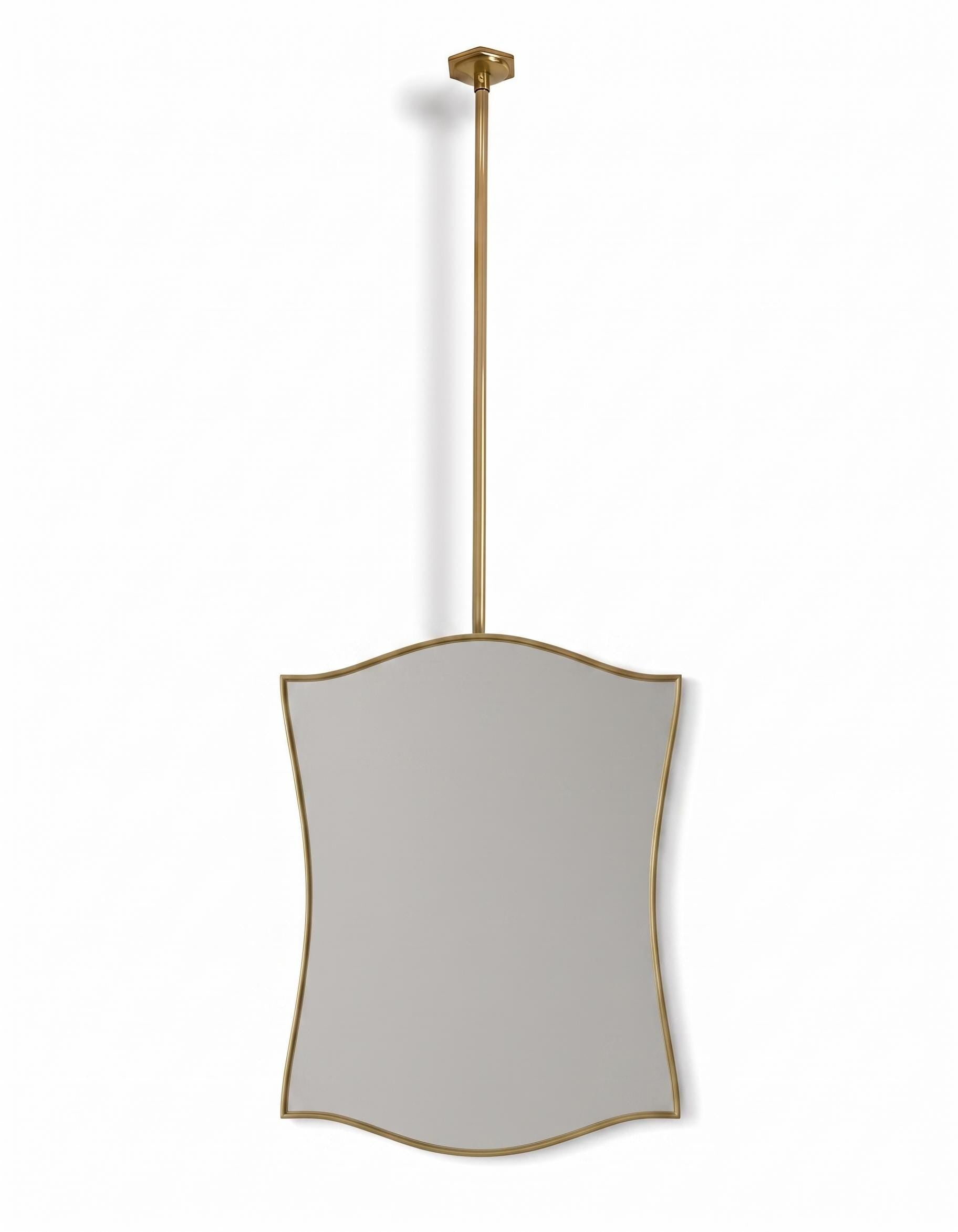Suspended sculptural brass mirror on white background