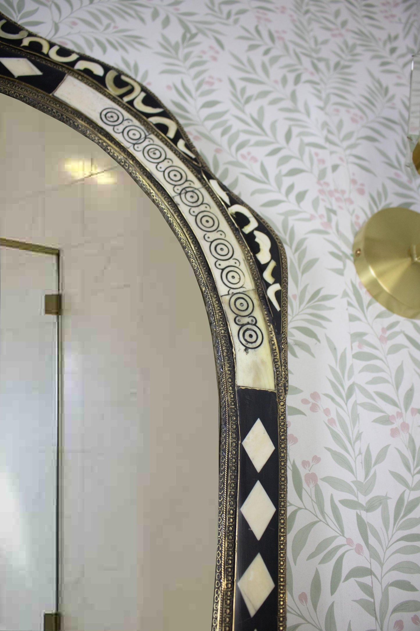 Top right detail of the mirror showing geometric and circular inlay patterns.