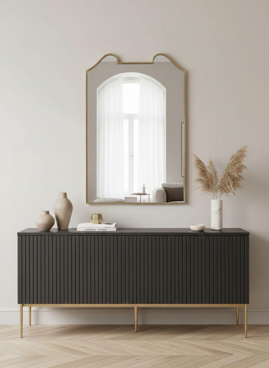Curved gold brass mirror styled above modern sideboard
