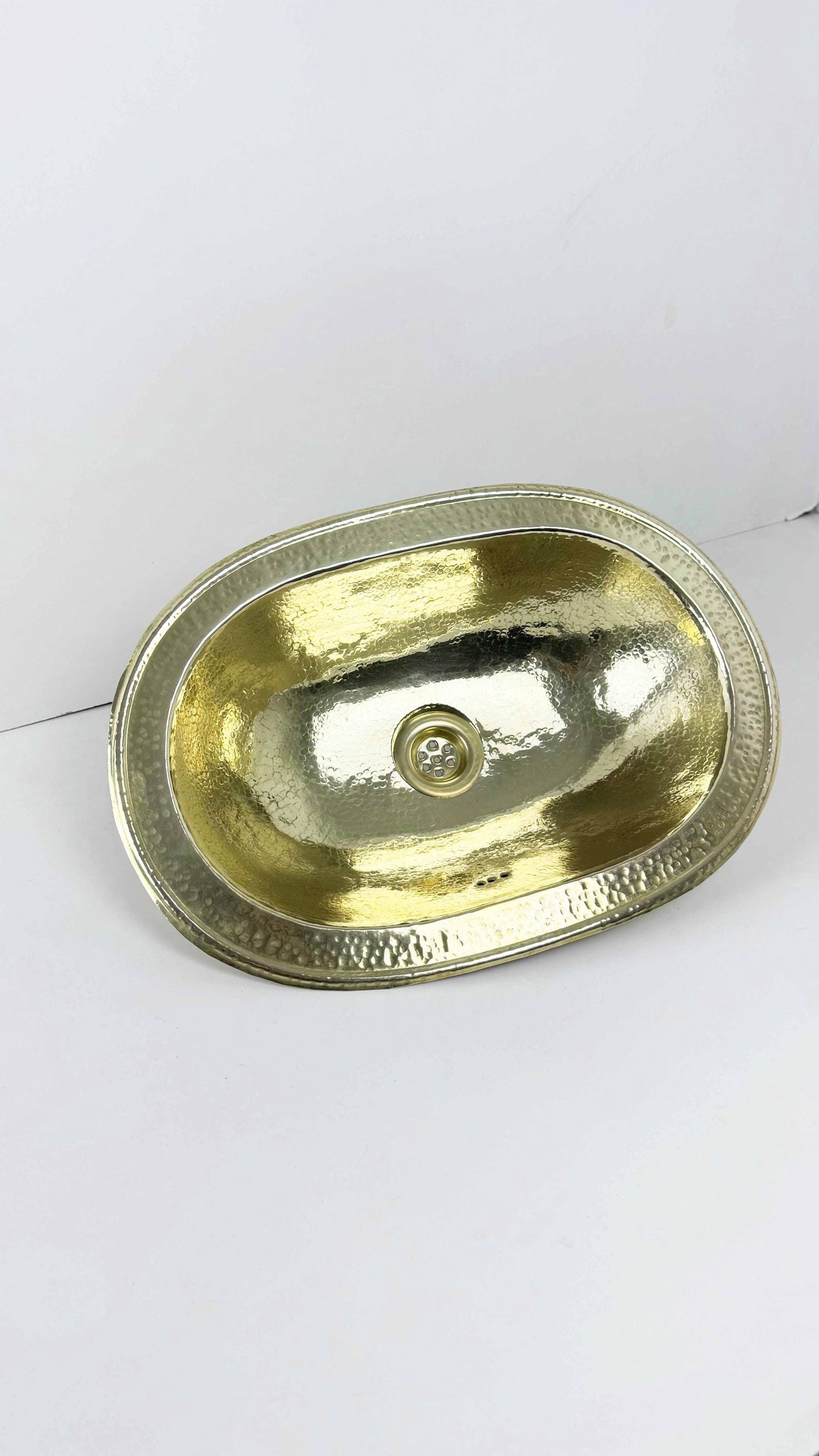 hammered brass bathroom sink on white background