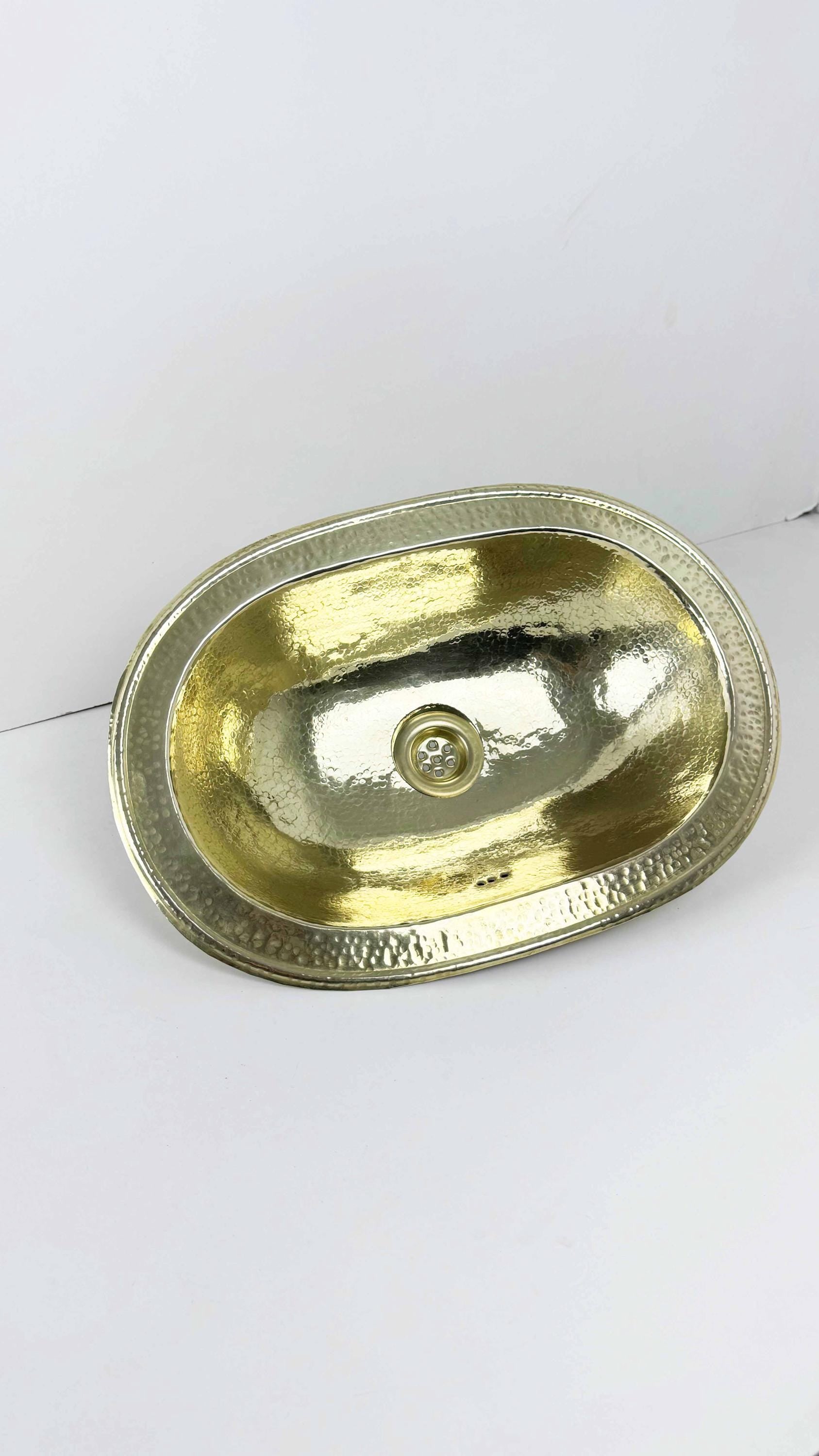 hammered brass bathroom sink on white background