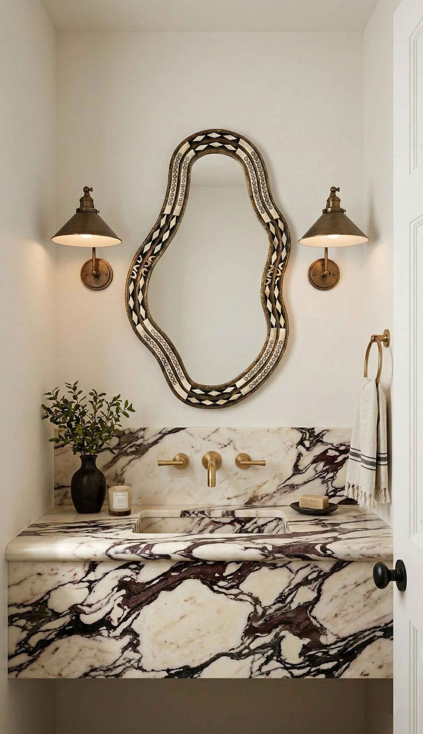 Artisan bone inlay mirror over marble vanity with brass sconces