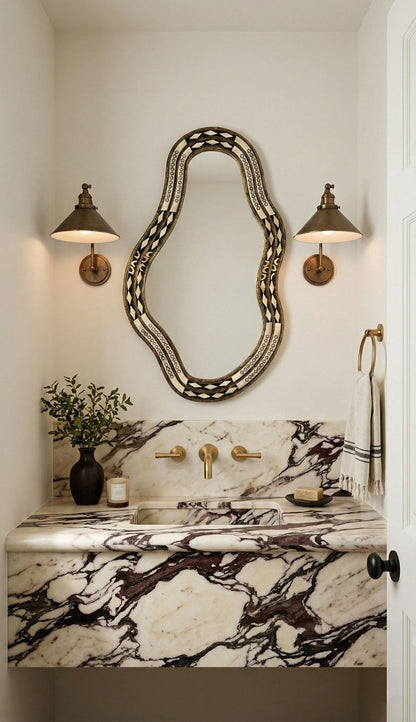 Artisan bone inlay mirror over marble vanity with brass sconces