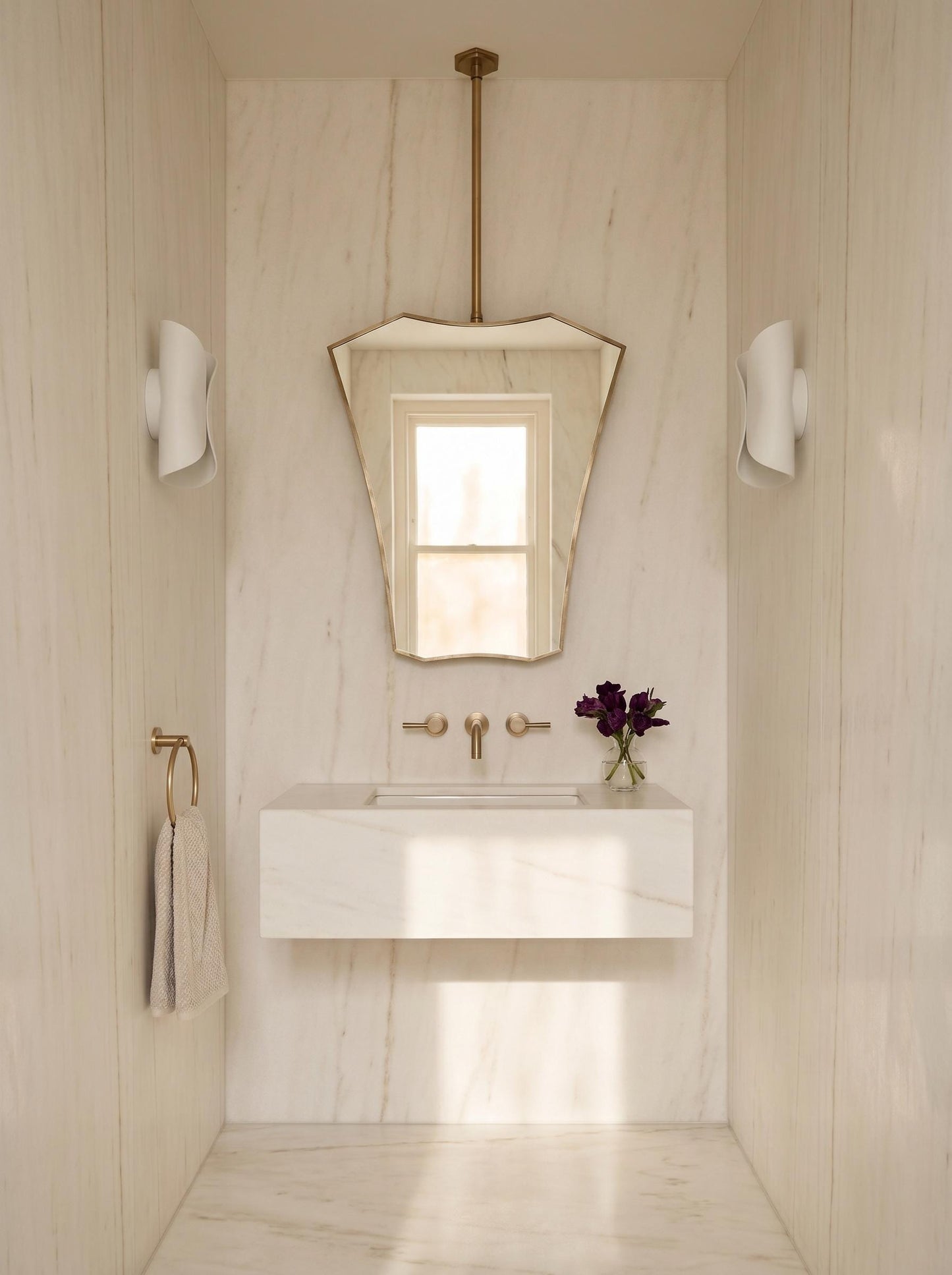 Sculptural brass ceiling mirror in minimalist bathroom