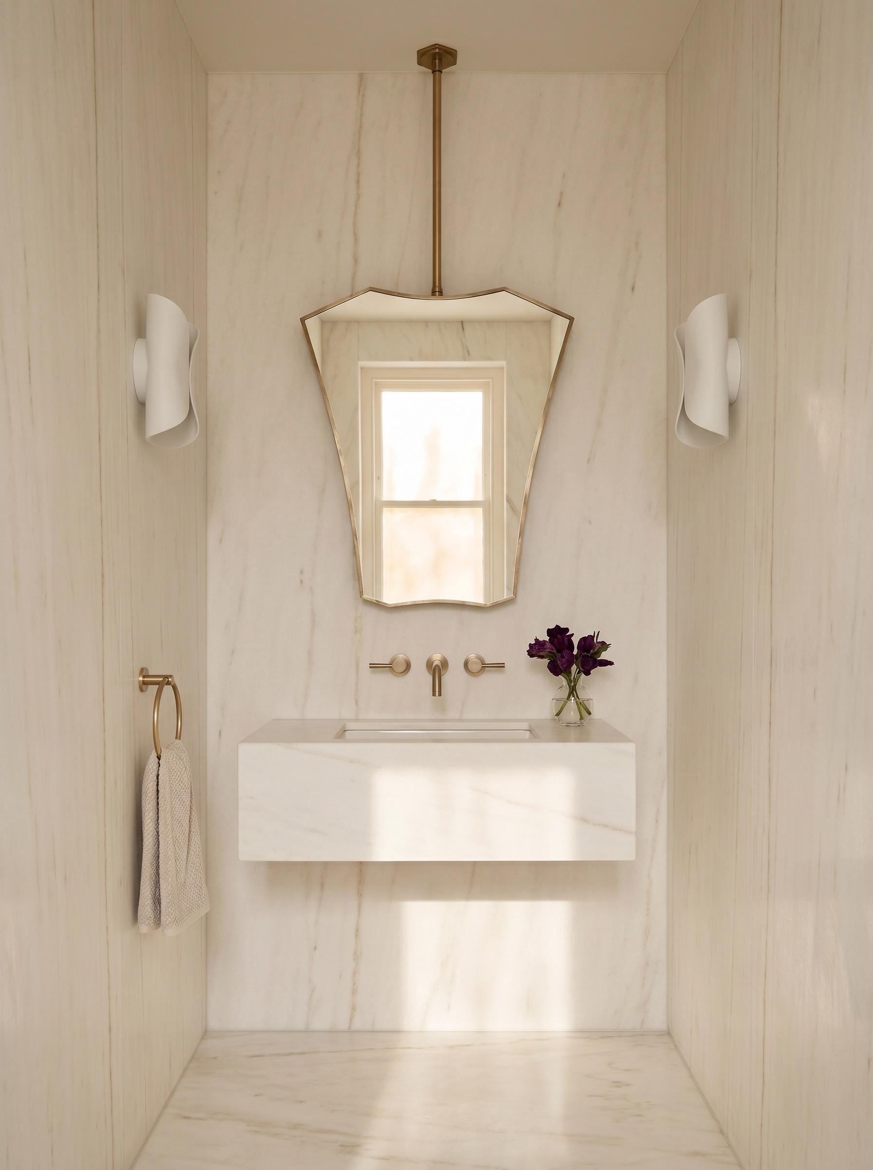 Sculptural brass ceiling mirror in minimalist bathroom